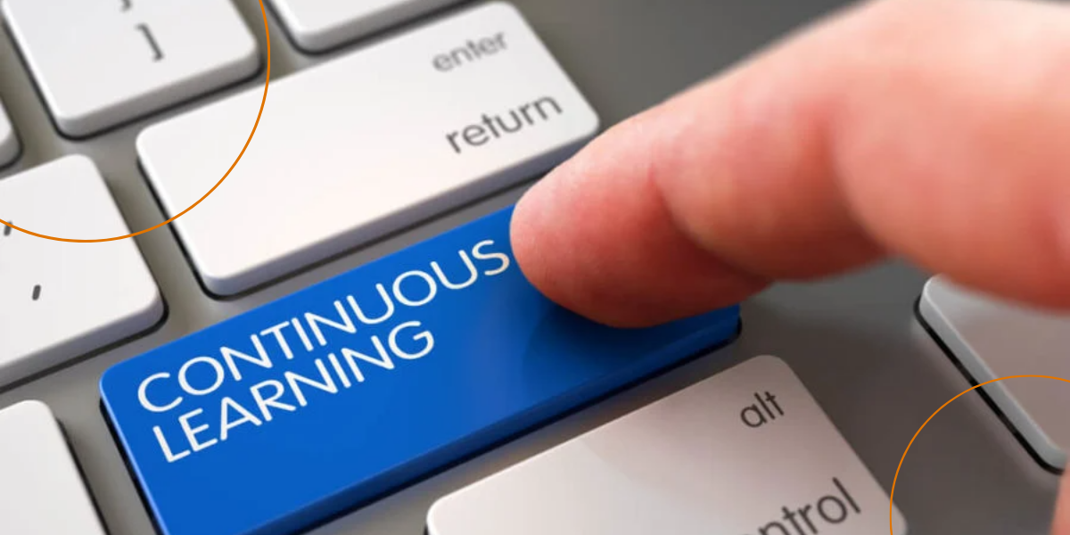 A man presses a keyboard key that reads "continuous learning"