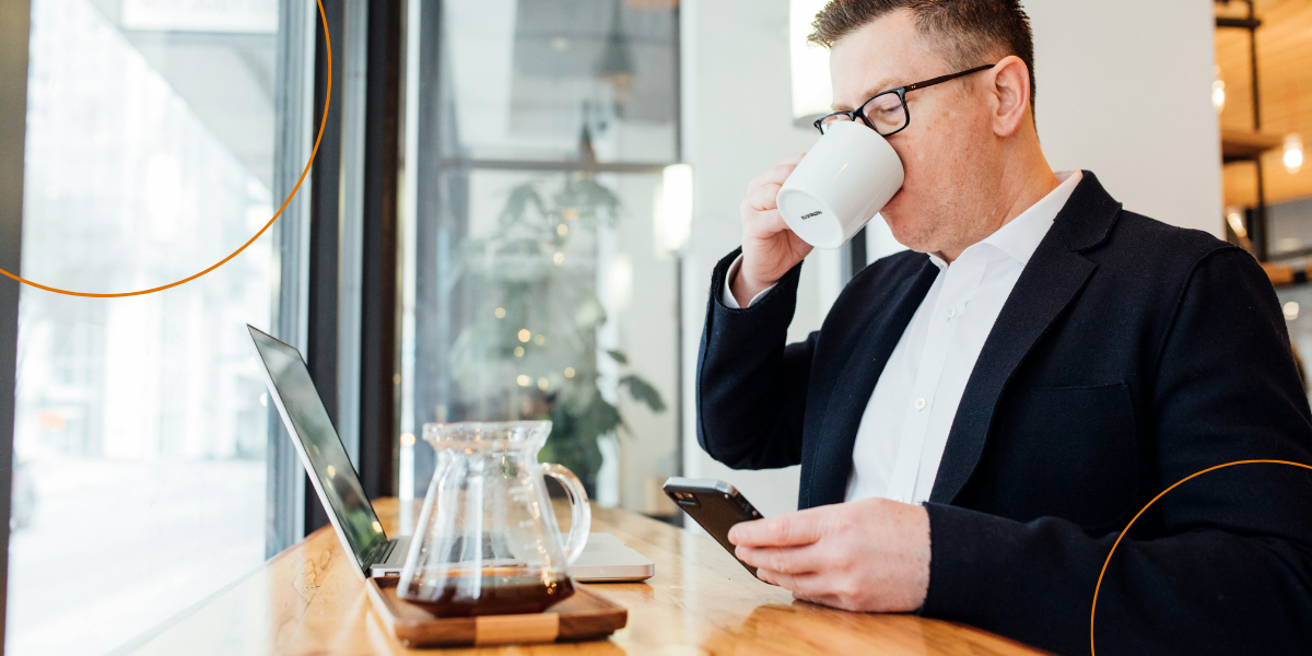 A man drinks a coffee whilst completing training in a cafe