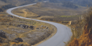 An image with a road surrounded by mountains.